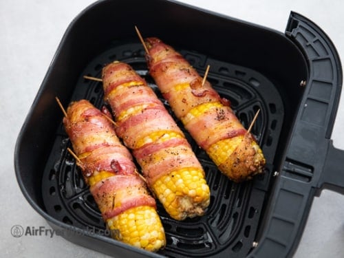 Cooked bacon wrapped corn in air fryer basket