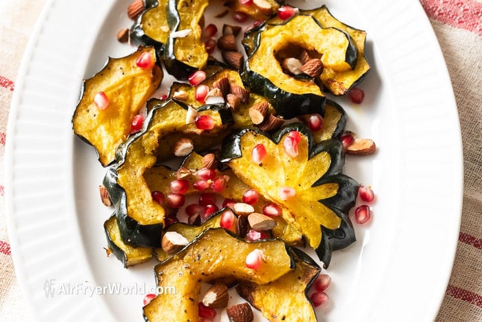 cooked acorn squash on plate with pomegranates 