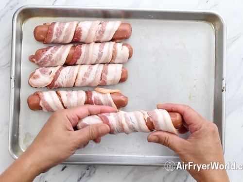 Wrapping hot dog with bacon