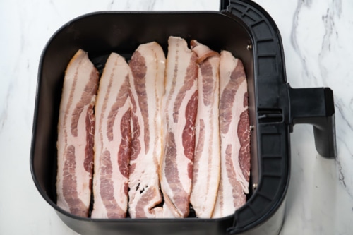 Uncooked bacon in single layer in air fryer