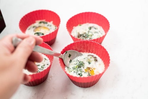 Gently stirring raw egg and milk in silicone muffin cups