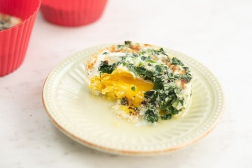 Baked egg broken into on a plate
