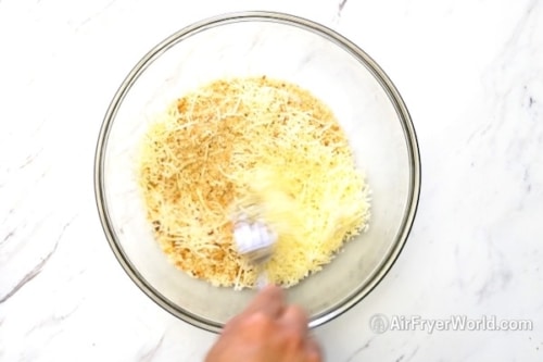 Mixing together bread crumbs and parmesan