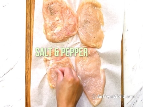 Seasoning pounded chicken breast with salt and pepper