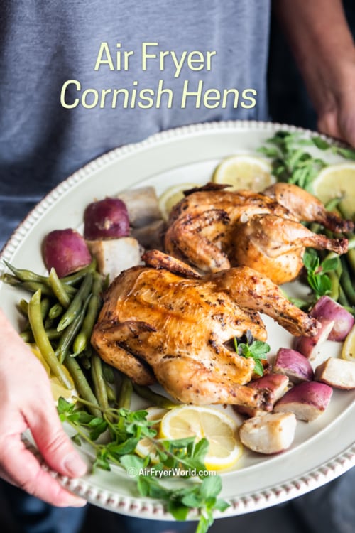 holding platter of air fryer Cornish hens 