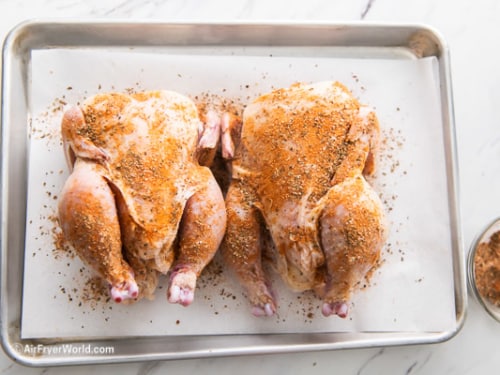 Cornish hens rubbed with spices on a sheet pan