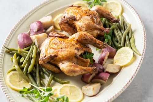 Cornish hens on platter with vegetables