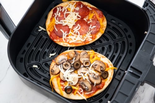 Flatbreads in air fryer with pizza toppings