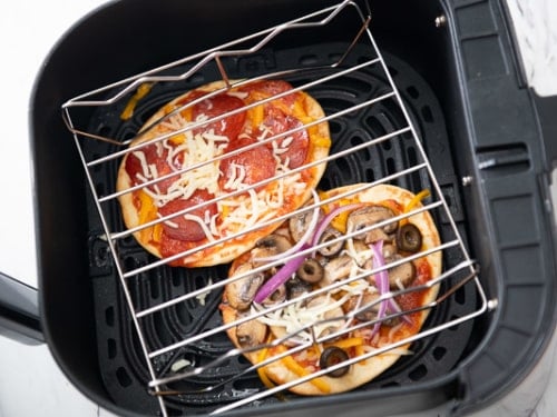 Wire rack over flatbread pizzas in air fryer