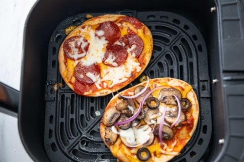 Cooked flatbread pizzas in air fryer basket