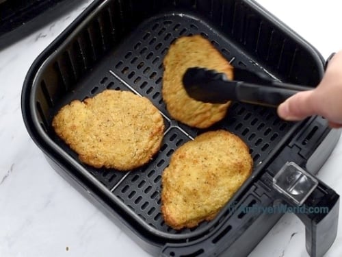 Flipping over chicken breast with tongs