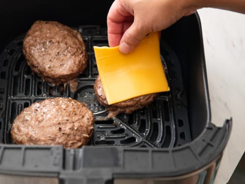 Adding cheese to cooked beef patty