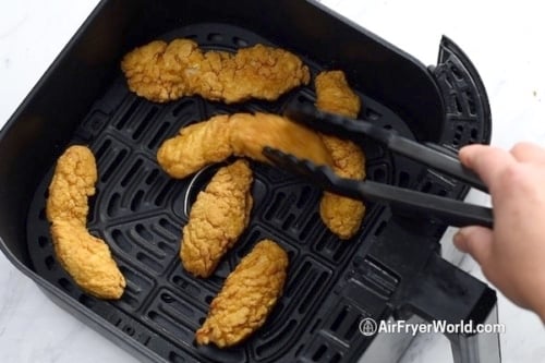 Flipping chicken strips over using tongs