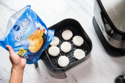 Frozen Grands biscuits spread in even layer in air fryer basket