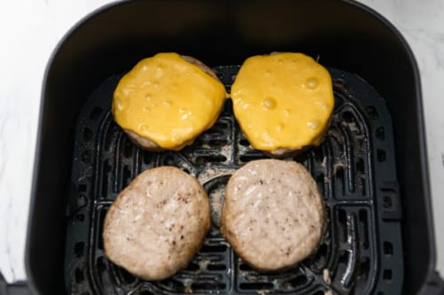Cheese melted onto cooked turkey burger patties in air fryer