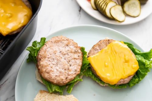 Plated turkey burgers with burger toppings on side