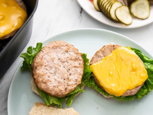 Plated turkey burgers with burger toppings on side