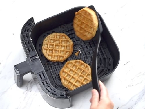 Flipping waffles over in air fryer with a spatula