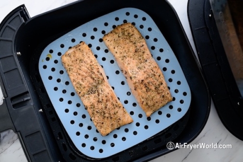 Air fried salmon in air fryer on a perforated silicone mat