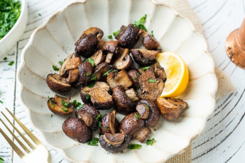 Mushrooms with a lemon wedge on a plate