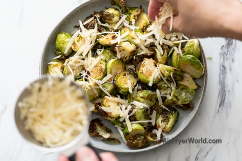 Sprinkling parmesan cheese over brussels sprouts