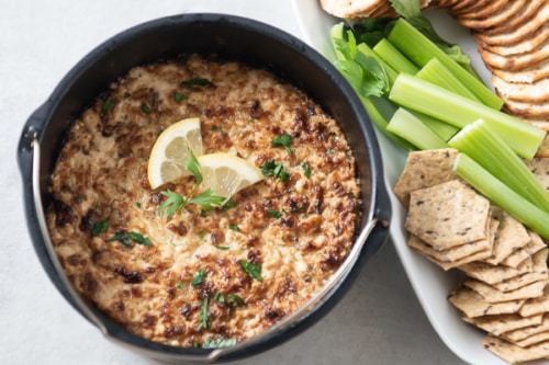 Hot crab dip served with crackers and vegetables