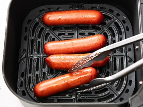 Turning the partially air fried hot link sausages in the air fryer