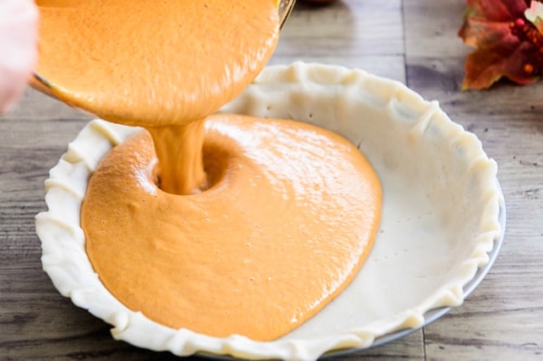 Pouring pie filling into uncooked pie crust