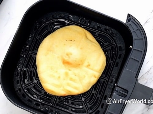 Cooked pizza crust in air fryer basket