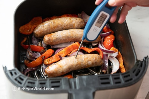 Checking internal sausage temperature with instant read thermometer