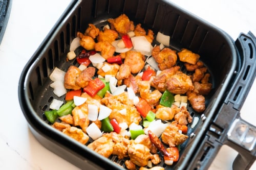 Cooked Chicken and vegetables in air fryer basket
