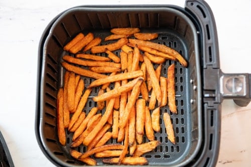 Cooked sweet potato fries in air fryer basket