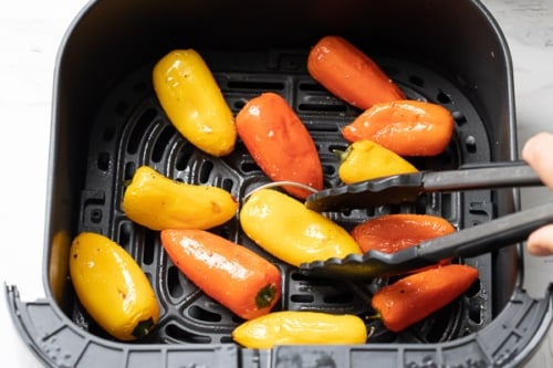 Turning half cooked peppers with tongs
