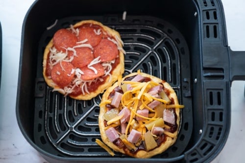 Topped uncooked pizzas in air fryer