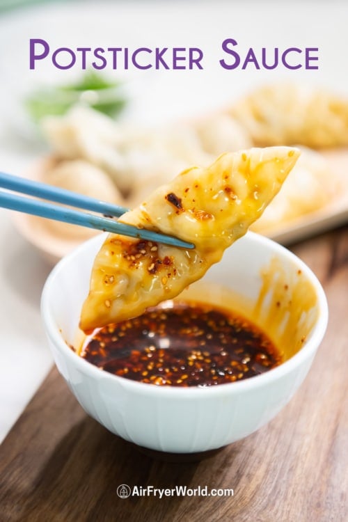 chopstick holding potsticker in dumpling sauce or wonton chili sauce