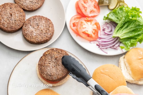 Cooked Impossible burger patty being placed on bun