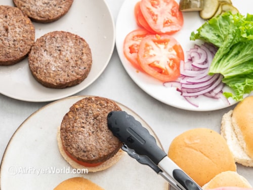 Cooked Impossible burger patty being placed on bun