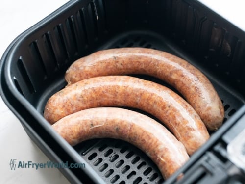 Raw bratwursts in air fryer basket