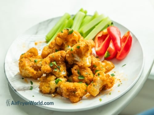 Finished air fried cauliflower on a plate with veggies