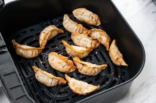 Fully cooked dumplings in air fryer basket
