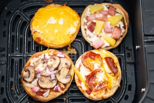 Cooked English muffin pizzas in air fryer basket