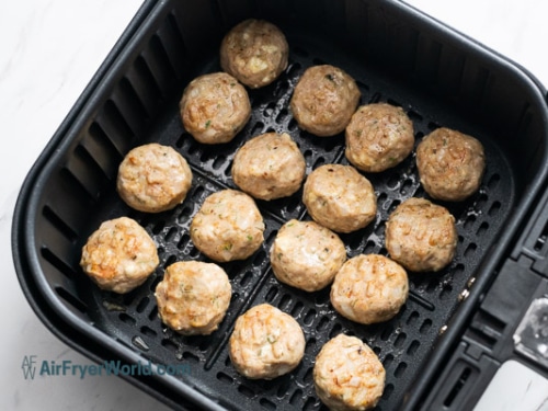 Half cooked meatballs in air fryer basket