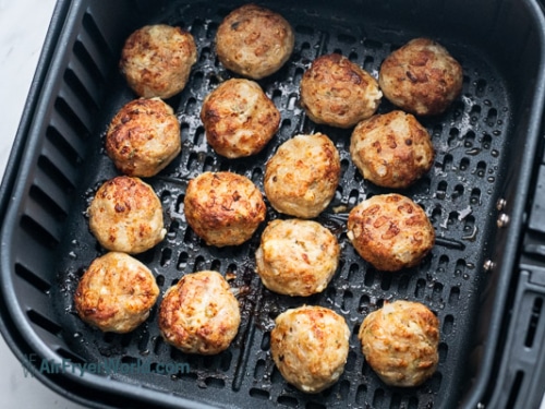 Cooked meatballs in air fryer basket