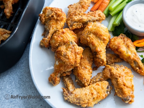 Parmesan wings on a plate with vegetables and ranch