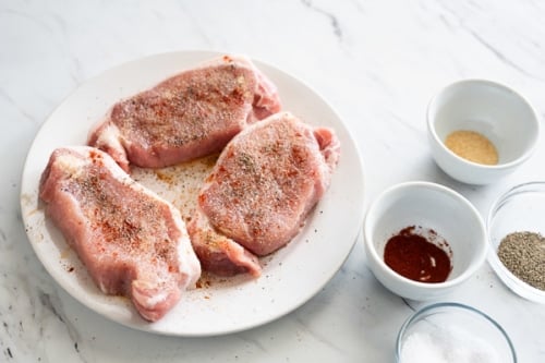 seasoned raw pork chops on plate