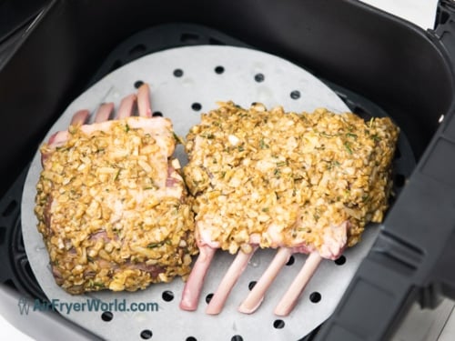 Uncooked crusted lamb rack in air fryer basket