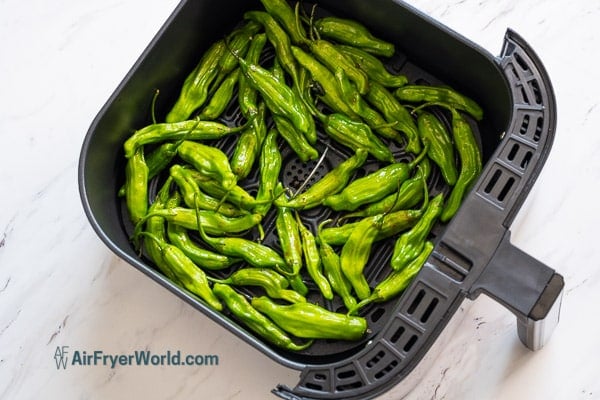 raw shishito peppers in air fryer basket