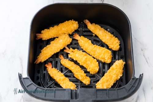 single layer of frozen shrimp tempura in air fryer basket