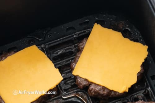 cheese slice on top of cooked burger patty in air fryer