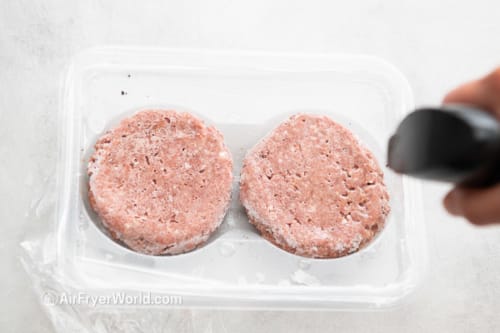 Frozen Beyond burgers being sprayed with oil